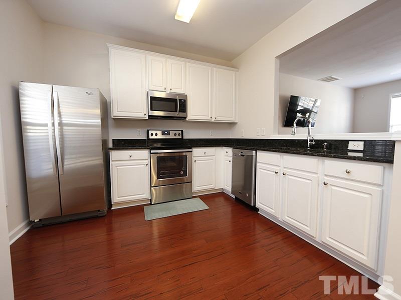 8210 Clasara Circle Raleigh, NC 27613 - Photo 5 of 14 a kitchen with granite countertop white cabinets and stainless steel appliances