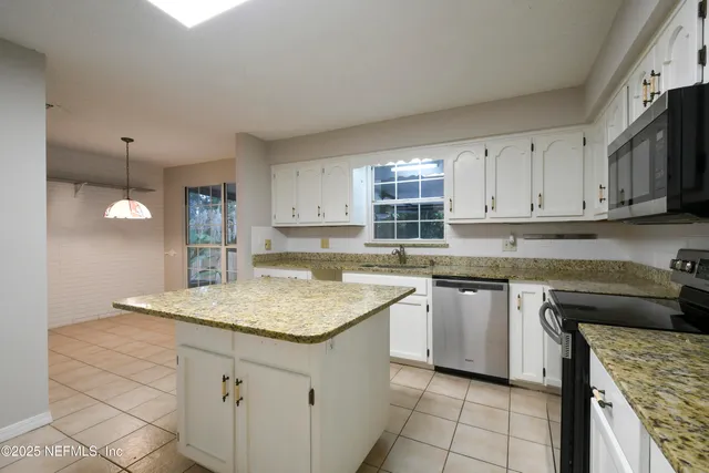 a kitchen with stainless steel appliances granite countertop a sink stove and cabinets