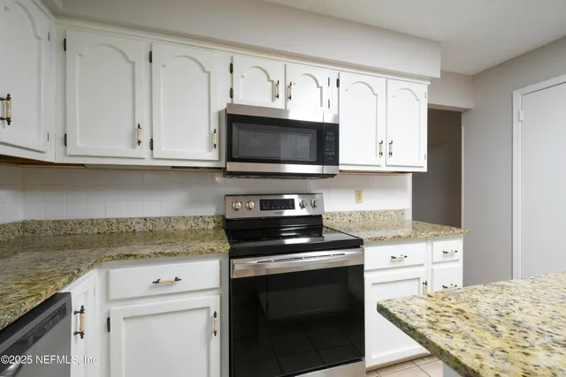 a kitchen with cabinets appliances and a sink