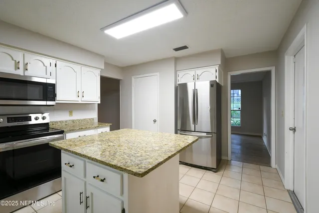 a kitchen with stainless steel appliances granite countertop a refrigerator and a stove top oven
