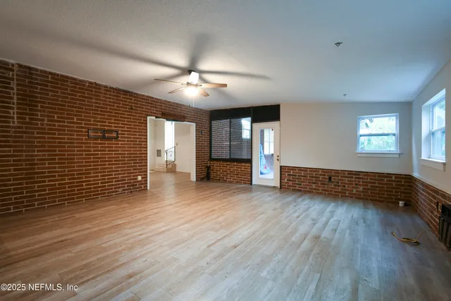 a view of a livingroom with wooden floor and a ceiling fan