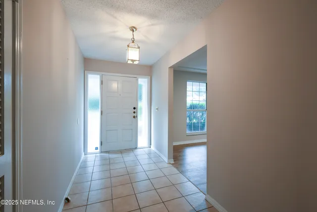 a view of a hallway with wooden floor and chandelier