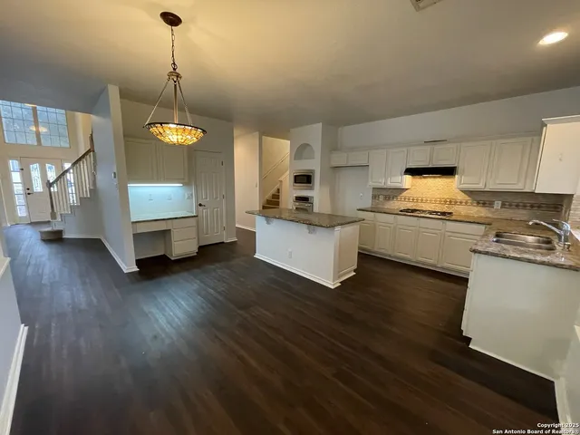 a kitchen with sink cabinets and wooden floor