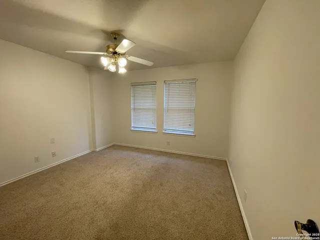 an empty room with a window and a fan