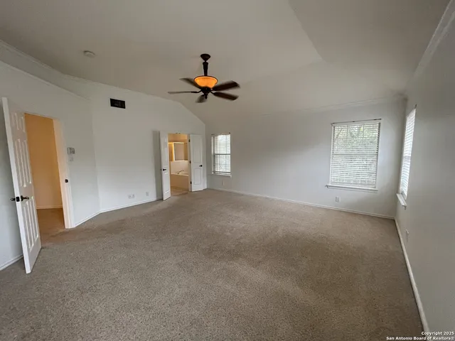 en empty room with windows and ceiling fan