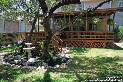 a view of a backyard with a small deck and a garden