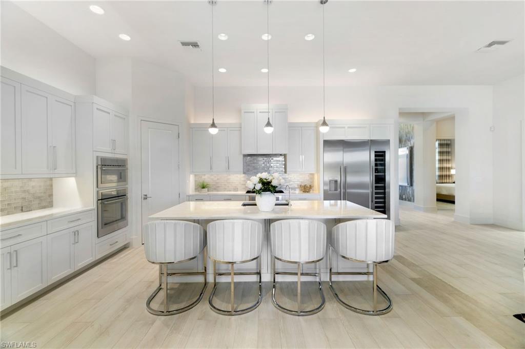 18488 Miromar Lakes Boulevard Miromar Lakes, FL 33913 - Photo 11 of 48 a large kitchen with dining table and chairs