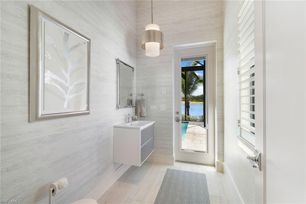 18488 Miromar Lakes Boulevard Miromar Lakes, FL 33913 - Photo 23 of 48 a view of a hallway with wooden floor and a bathroom