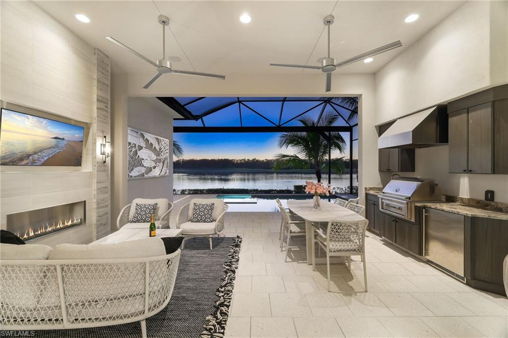 18488 Miromar Lakes Boulevard Miromar Lakes, FL 33913 - Photo 26 of 48 a living room with furniture a fireplace and chandelier