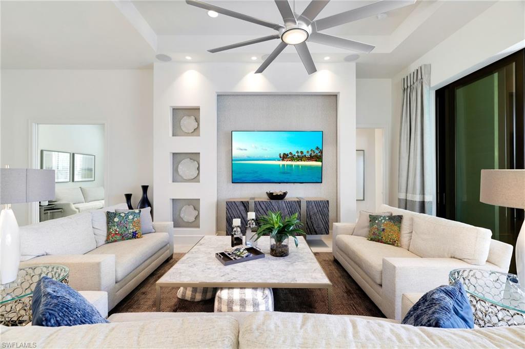 18488 Miromar Lakes Boulevard Miromar Lakes, FL 33913 - Photo 6 of 48 a living room with furniture a large window and a flat screen tv