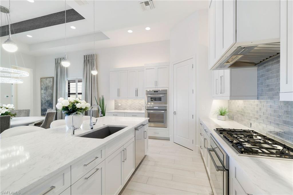 18488 Miromar Lakes Boulevard Miromar Lakes, FL 33913 - Photo 7 of 48 a kitchen with sink a stove and cabinets