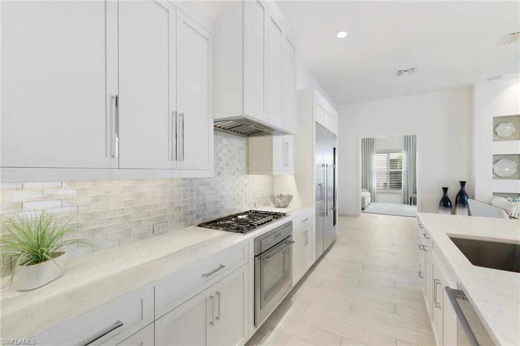 18488 Miromar Lakes Boulevard Miromar Lakes, FL 33913 - Photo 8 of 48 a kitchen with granite countertop a sink stove and cabinets