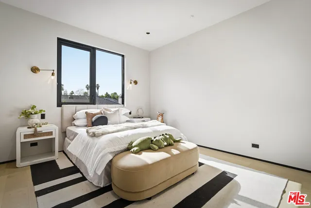 a spacious bedroom with a bed and a large window