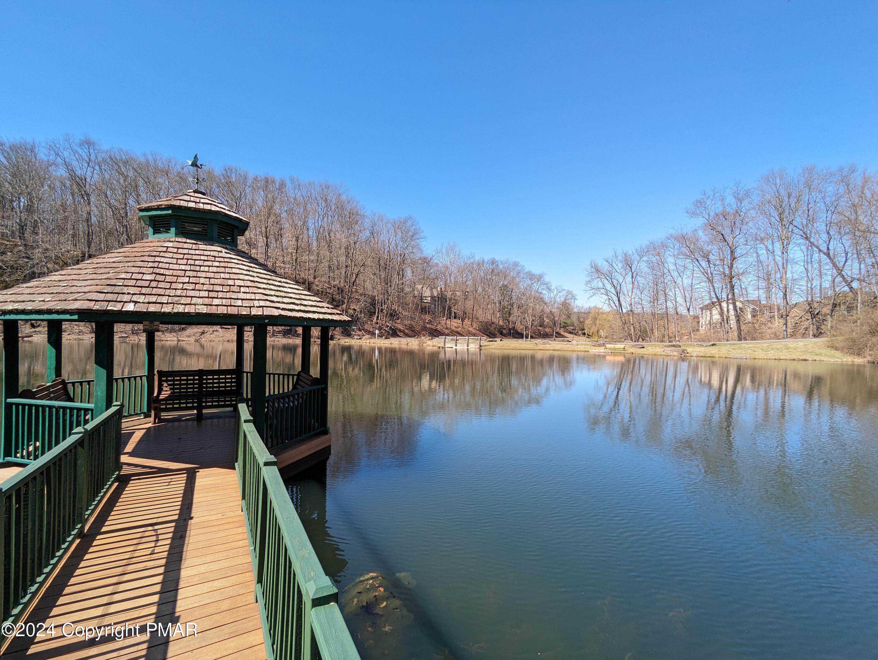 507 McKinley Way East Stroudsburg, PA 18301 - Photo 3 of 9 a roof deck with table and chairs under an umbrella with wooden floor and fence