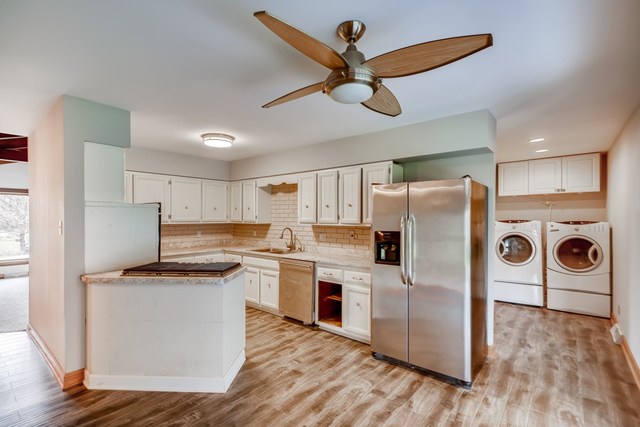 1331 West Maple Road New Lenox, IL 60451 - Photo 6 of 17 a kitchen with kitchen island white cabinets and refrigerator