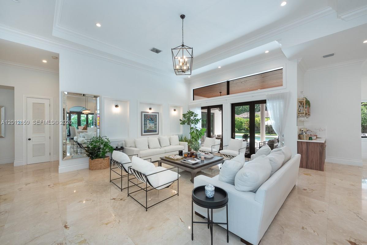 12311 Southwest 94th Avenue Miami, FL 33176 - Photo 4 of 32 a living room with furniture a chandelier and a dining table