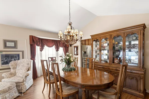 a view of a dining room with furniture a rug and wooden floor