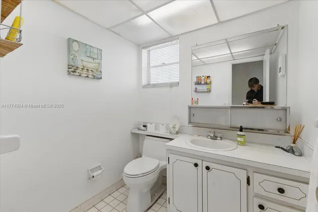 a bathroom with a toilet a sink and mirror