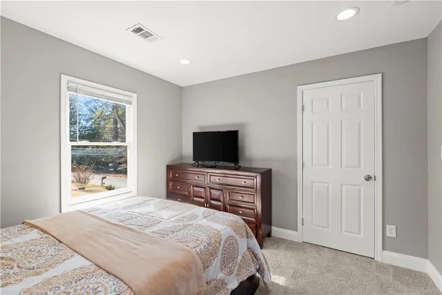 a large bed sitting in a bedroom next to a window