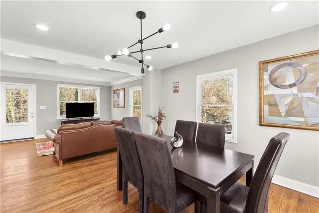 a kitchen with stainless steel appliances granite countertop a refrigerator a stove top oven a sink dishwasher and white cabinets with wooden floor