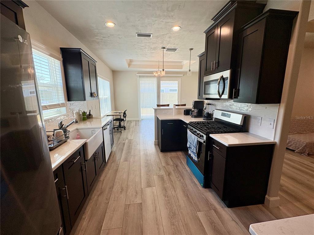 6737 Southwest 13th Lane Gainesville, FL 32607 - Photo 11 of 24 a kitchen with kitchen island granite countertop a sink counter top space and stainless steel appliances