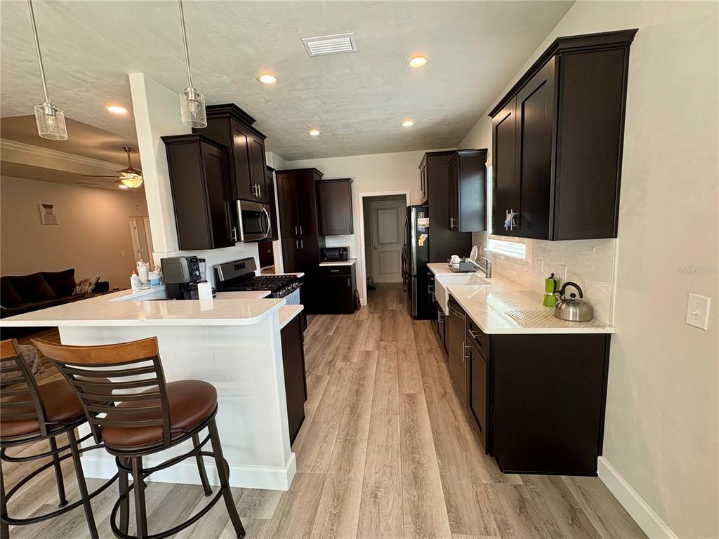 6737 Southwest 13th Lane Gainesville, FL 32607 - Photo 12 of 24 a kitchen with a table chairs refrigerator and microwave