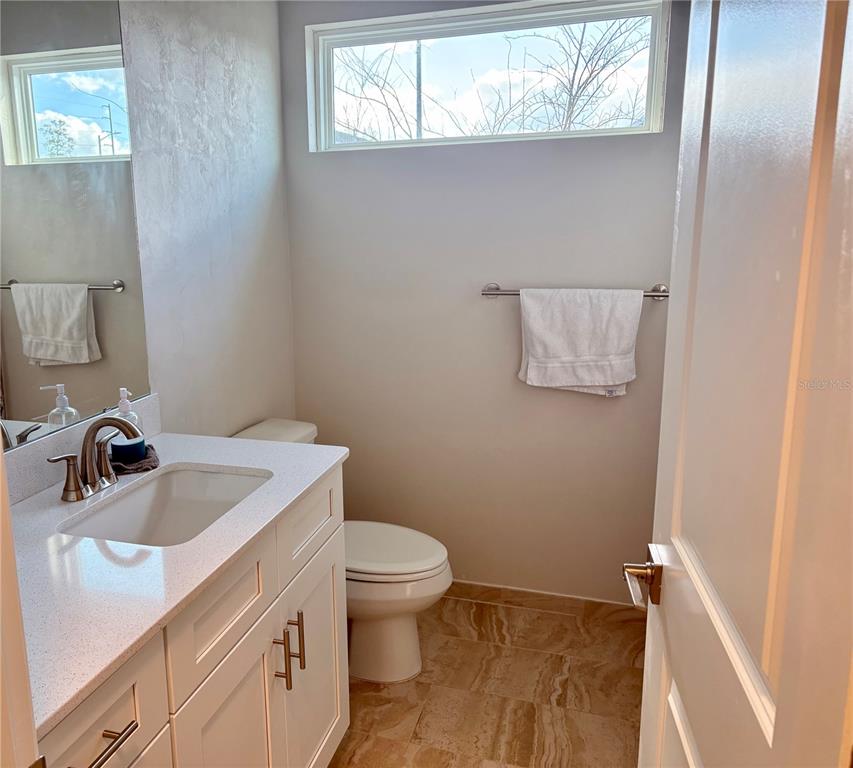 6737 Southwest 13th Lane Gainesville, FL 32607 - Photo 7 of 24 a bathroom with a sink a toilet and a window