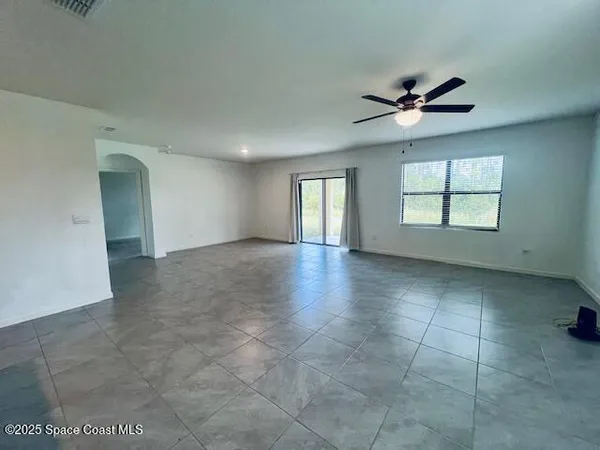 a view of a livingroom with a ceiling fan and window