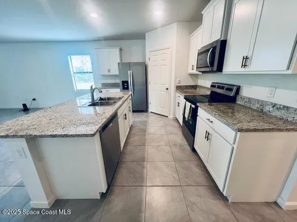 a kitchen with stainless steel appliances granite countertop a sink stove and cabinets