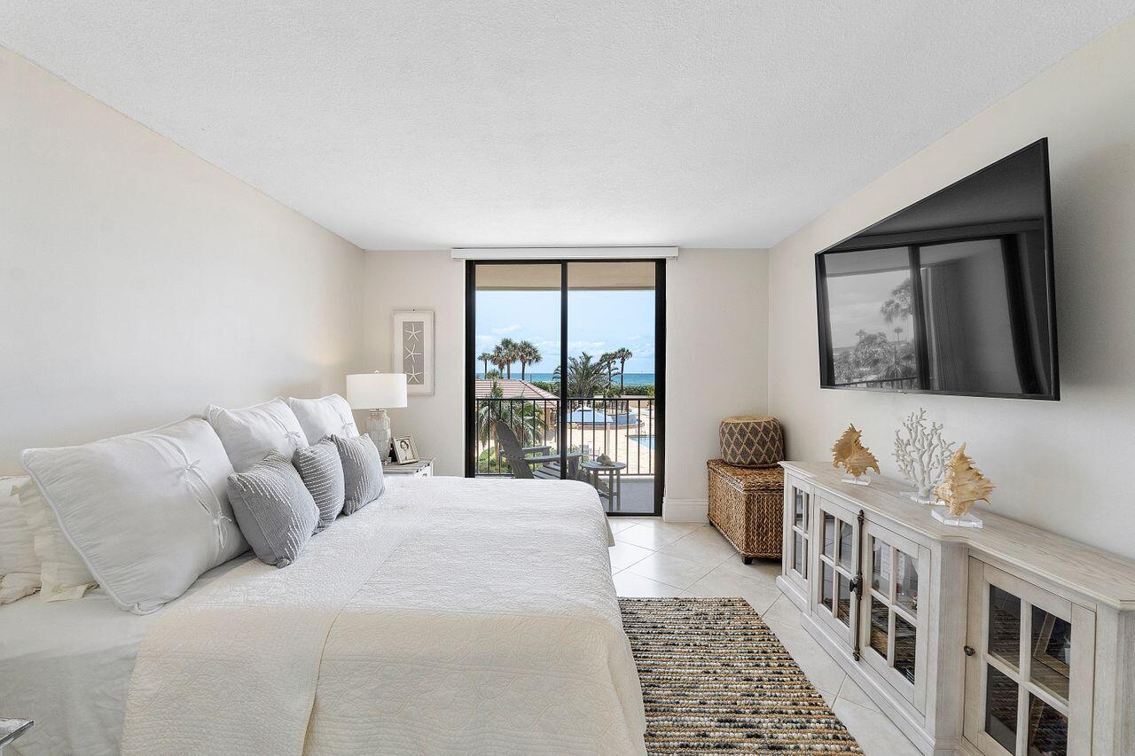 100 Ocean Trail Way, Unit 207 Jupiter, FL 33477 - Photo 18 of 61 a bedroom with a bed a couch and a window