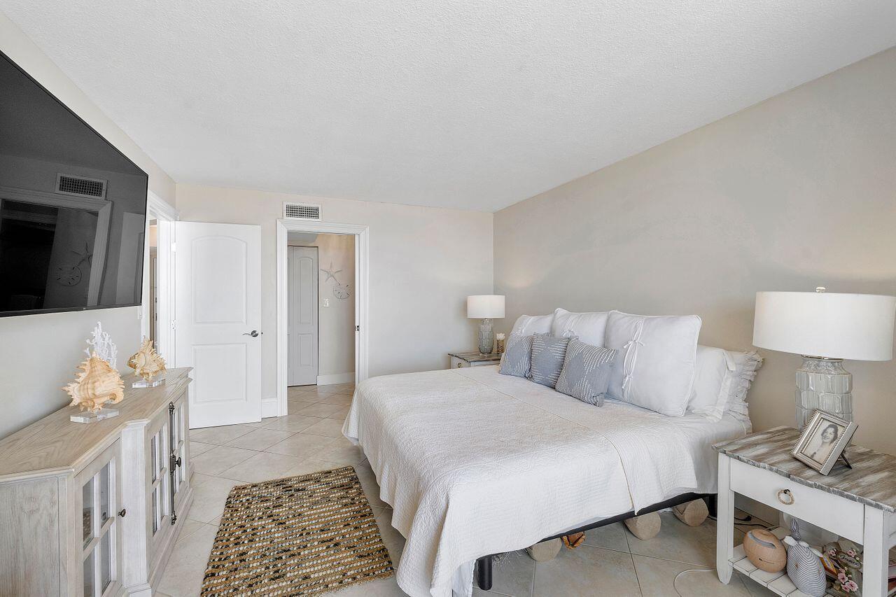 100 Ocean Trail Way, Unit 207 Jupiter, FL 33477 - Photo 19 of 61 a bedroom with a bed and a flat screen tv