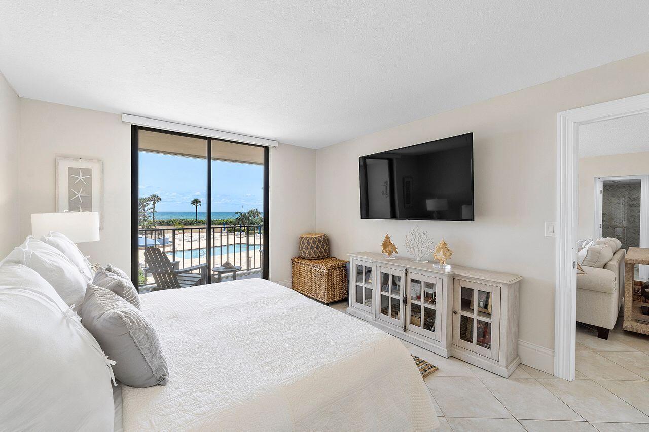 100 Ocean Trail Way, Unit 207 Jupiter, FL 33477 - Photo 20 of 61 a bedroom with a bed and a flat screen tv