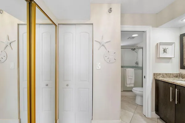 a bathroom with a granite countertop sink a toilet and shower