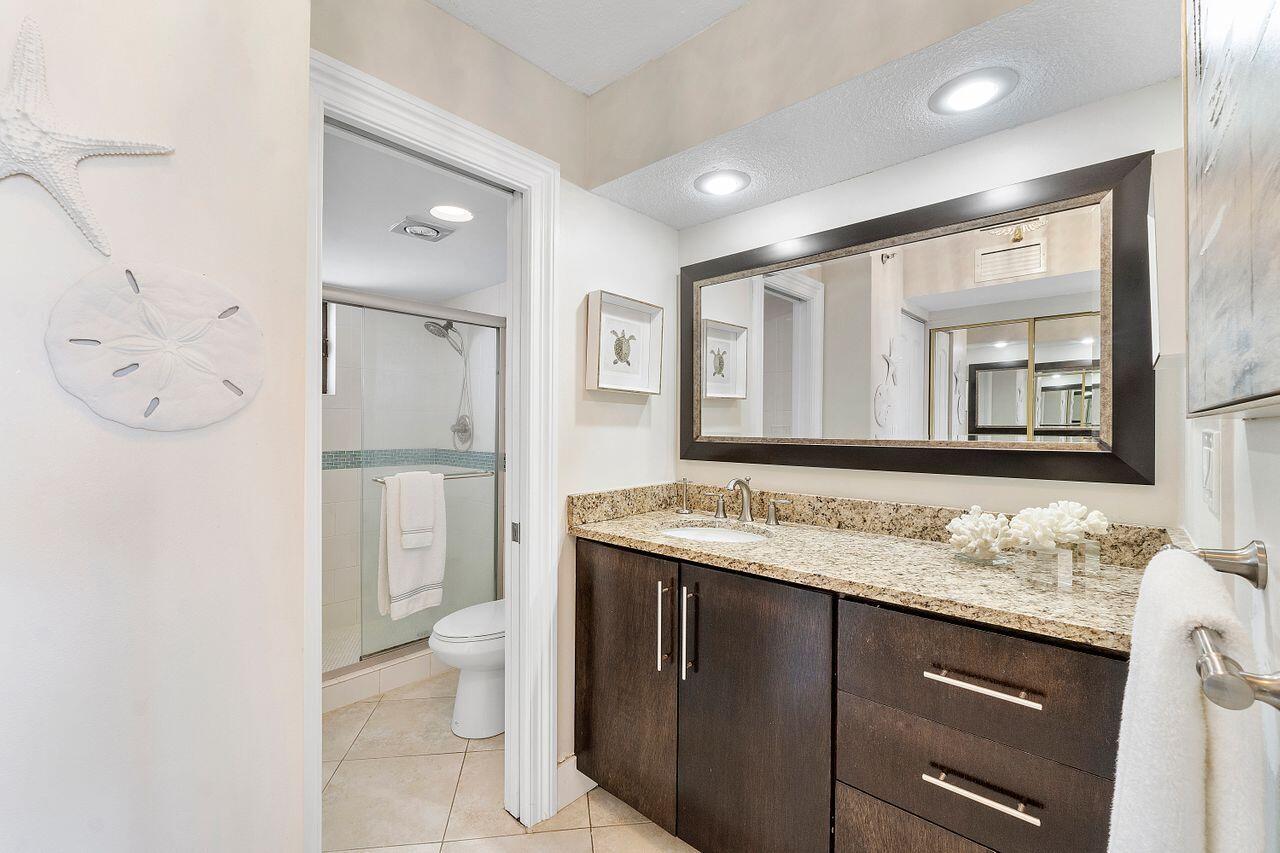 100 Ocean Trail Way, Unit 207 Jupiter, FL 33477 - Photo 22 of 61 a bathroom with a granite countertop sink mirror and toilet