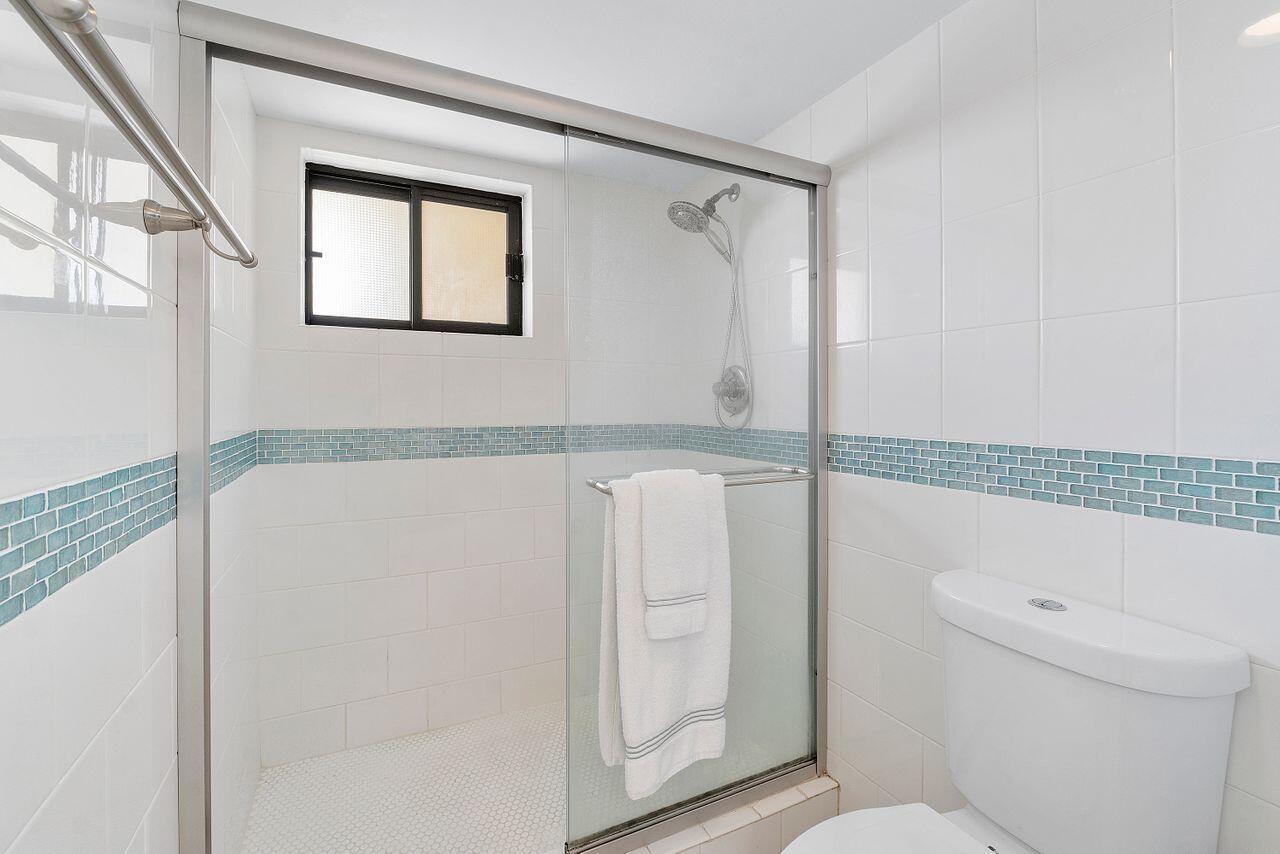 100 Ocean Trail Way, Unit 207 Jupiter, FL 33477 - Photo 24 of 61 a bathroom with a granite countertop sink a toilet and shower