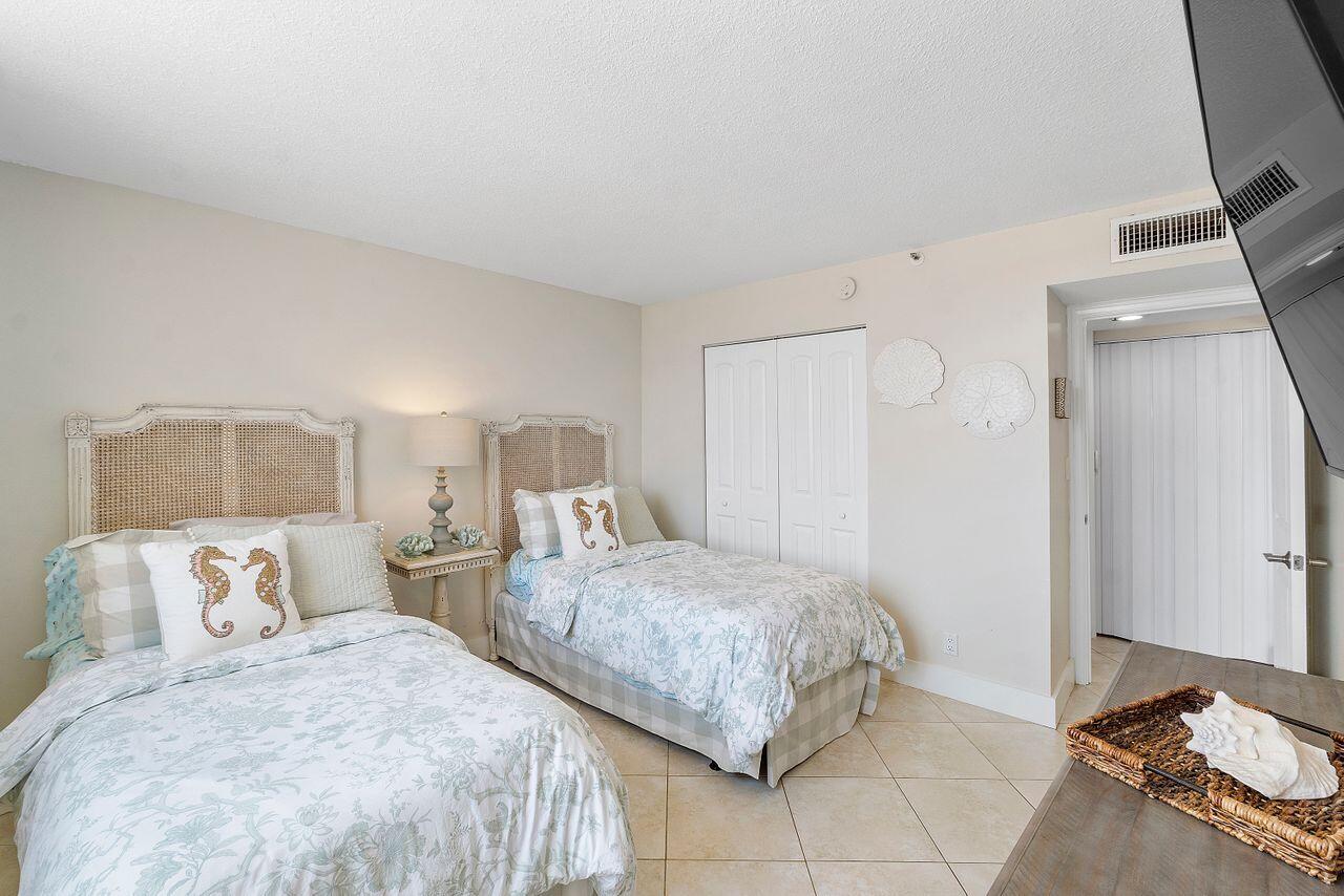 100 Ocean Trail Way, Unit 207 Jupiter, FL 33477 - Photo 28 of 61 a bedroom with two beds and a lamp