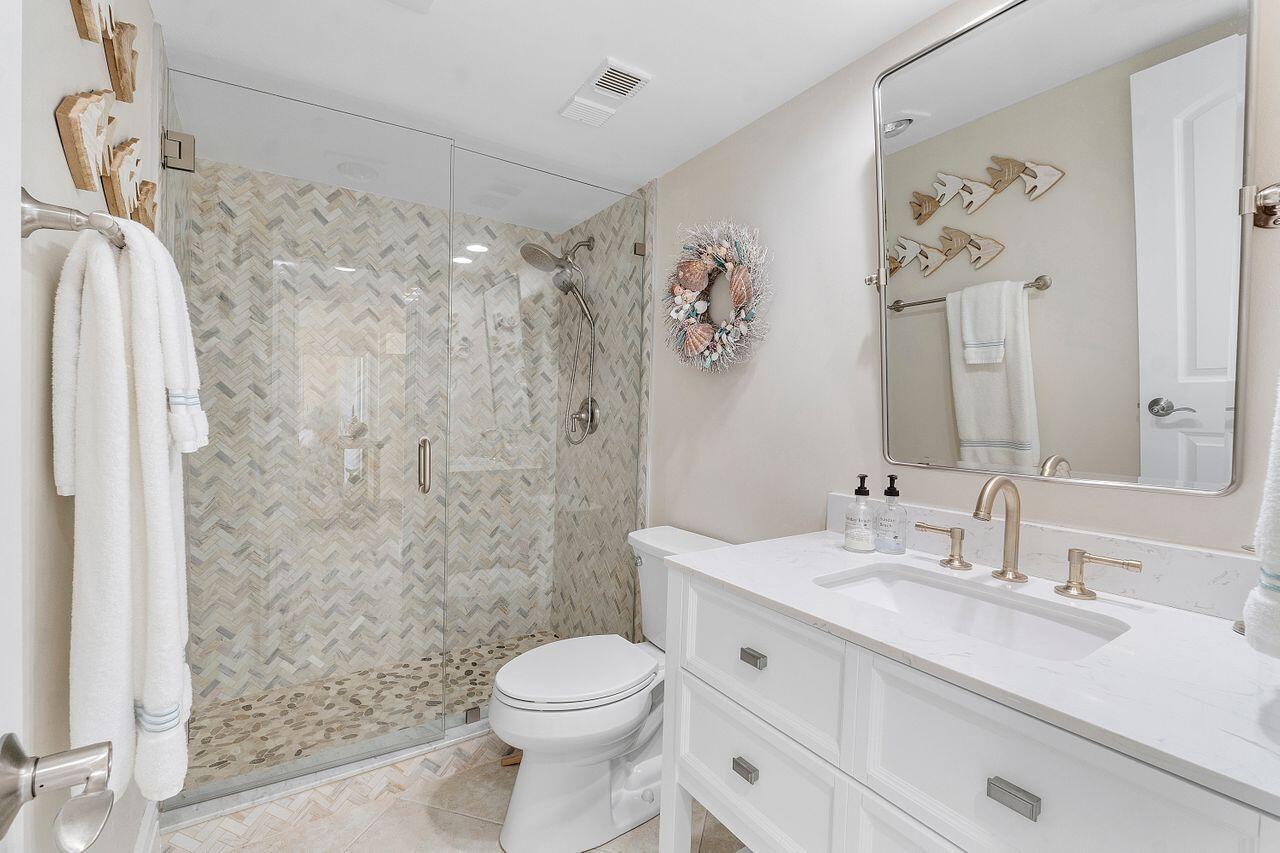 100 Ocean Trail Way, Unit 207 Jupiter, FL 33477 - Photo 30 of 61 a bathroom with a sink vanity mirror and toilet