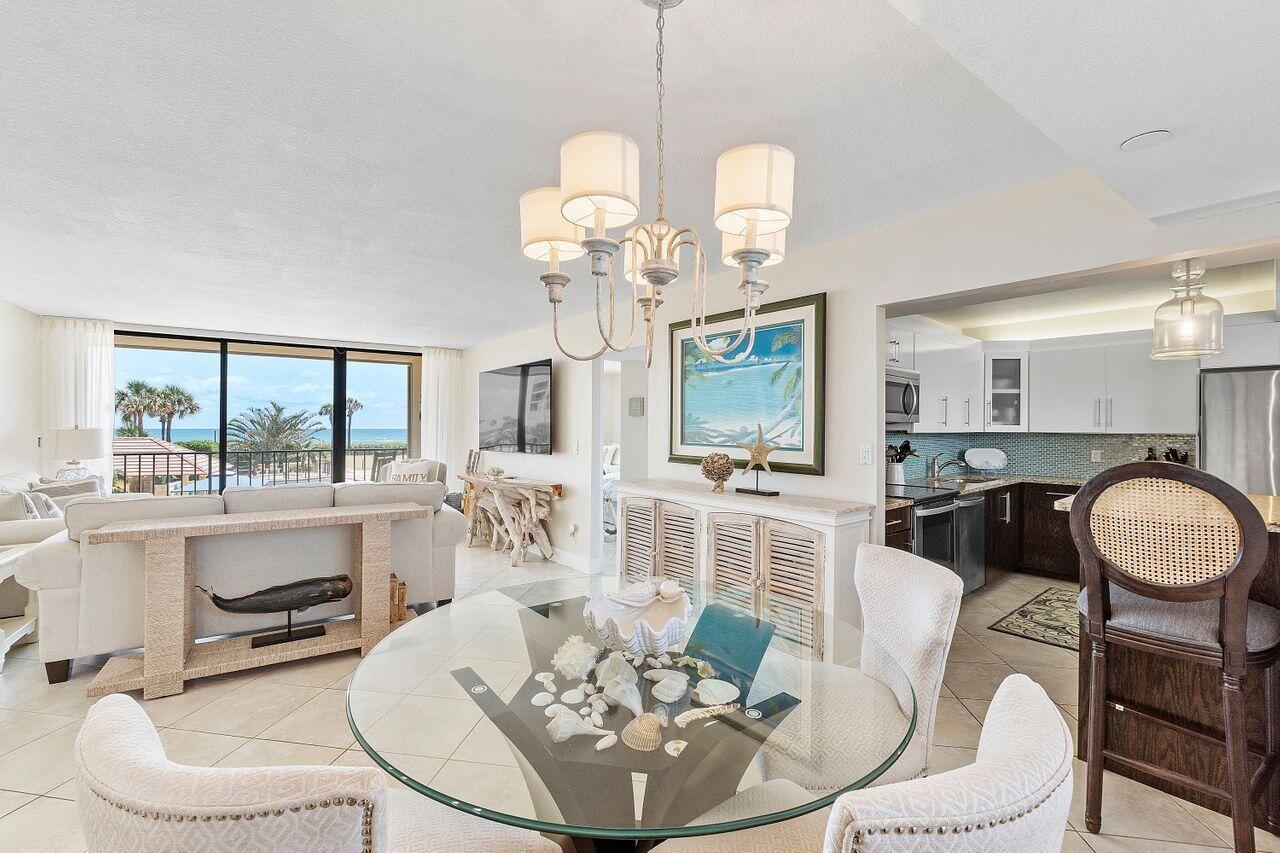 100 Ocean Trail Way, Unit 207 Jupiter, FL 33477 - Photo 3 of 61 a dining room with wooden floor a chandelier a glass table and chairs