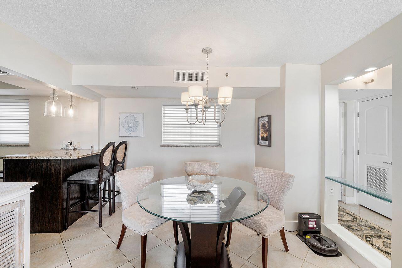 100 Ocean Trail Way, Unit 207 Jupiter, FL 33477 - Photo 10 of 61 a view of a dining room with furniture and chandelier