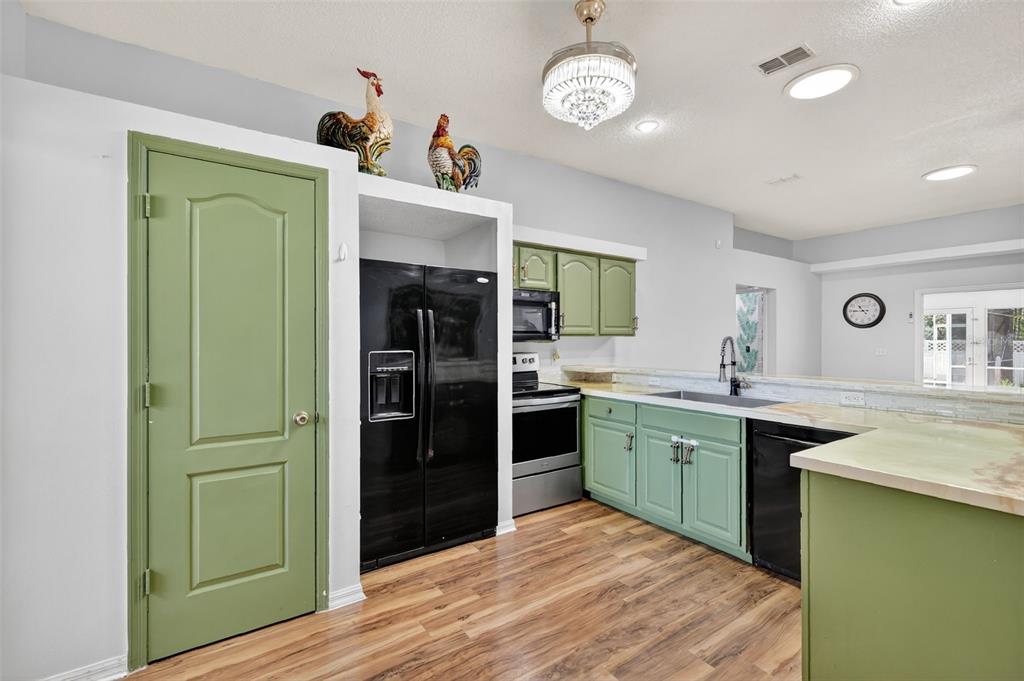 14520 Lost Lake Road Clermont, FL 34711 - Photo 14 of 47 a kitchen with a sink a refrigerator and cabinets