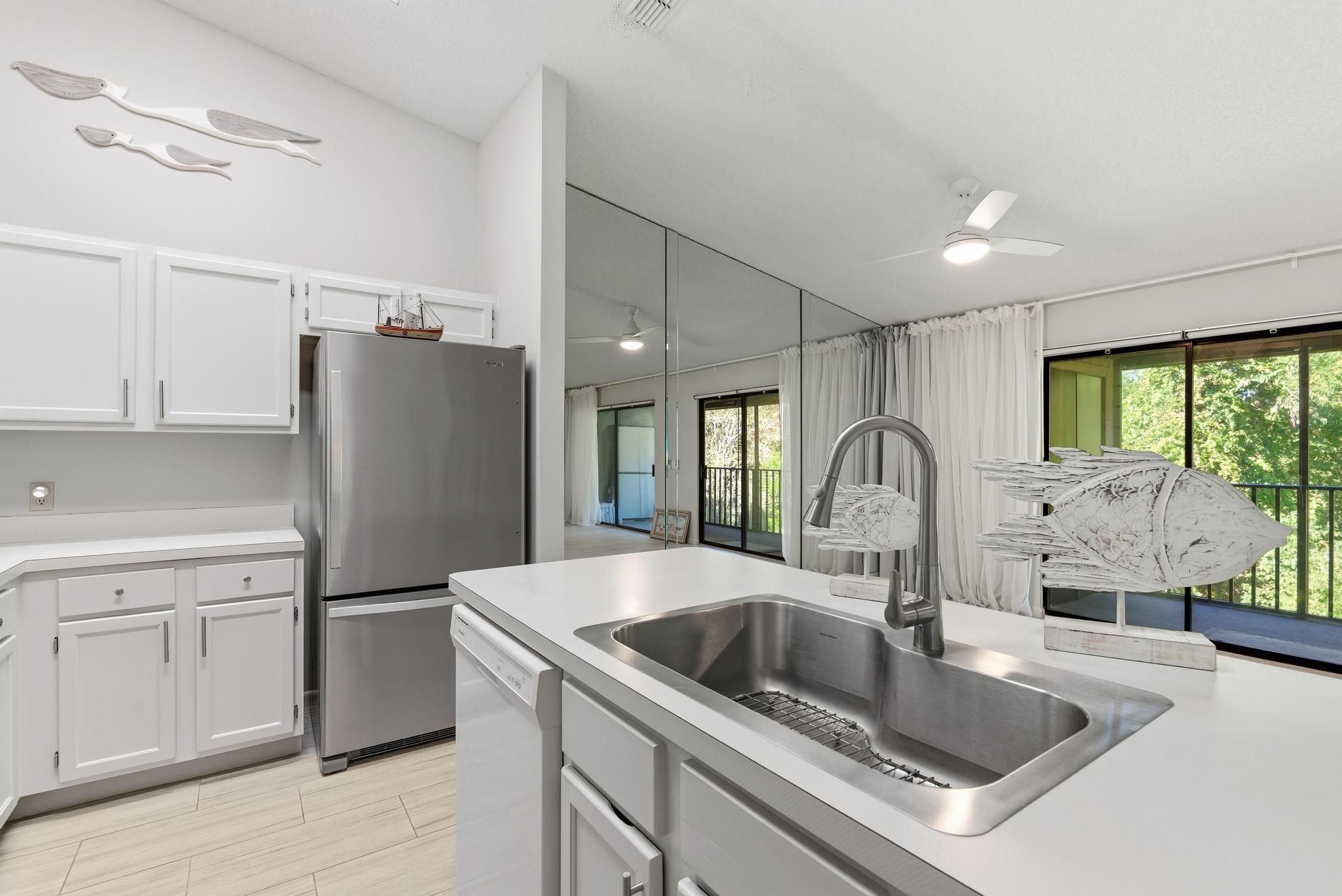 32 Navarra Court St. Augustine Shores, FL 32086 - Photo 18 of 40 a kitchen with stainless steel appliances granite countertop a refrigerator a sink a stove and white cabinets with wooden floor