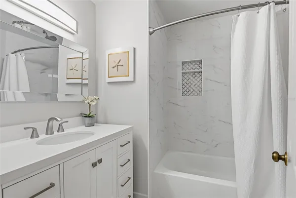 a kitchen with stainless steel appliances granite countertop a refrigerator a sink a stove and white cabinets with wooden floor