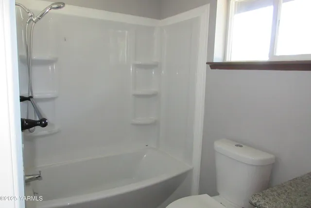 a bath room with a toilet and a bath tub