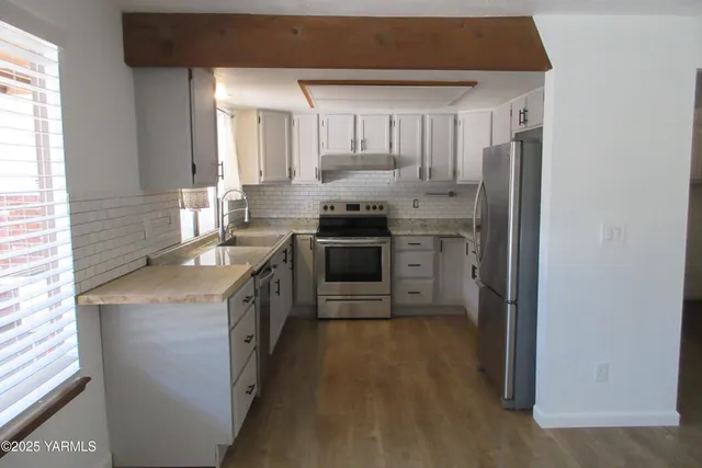a kitchen with stainless steel appliances a stove sink and refrigerator