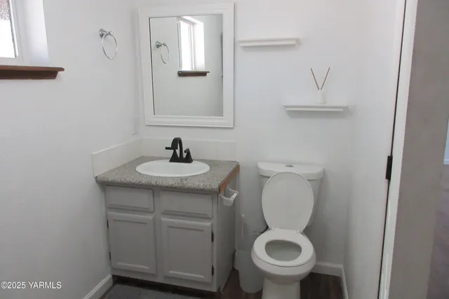 a bathroom with a toilet sink and mirror