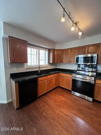 a kitchen with granite countertop stainless steel appliances and wooden cabinets