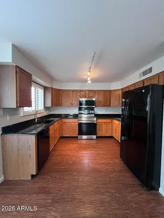a large kitchen with stainless steel appliances granite countertop a refrigerator and a stove top oven
