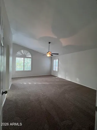 an empty room with windows and fan
