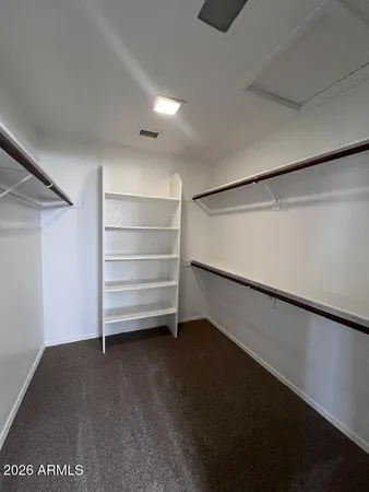 a view of walk in closet with empty racks