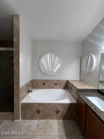 a bathroom with a tub sink and mirror